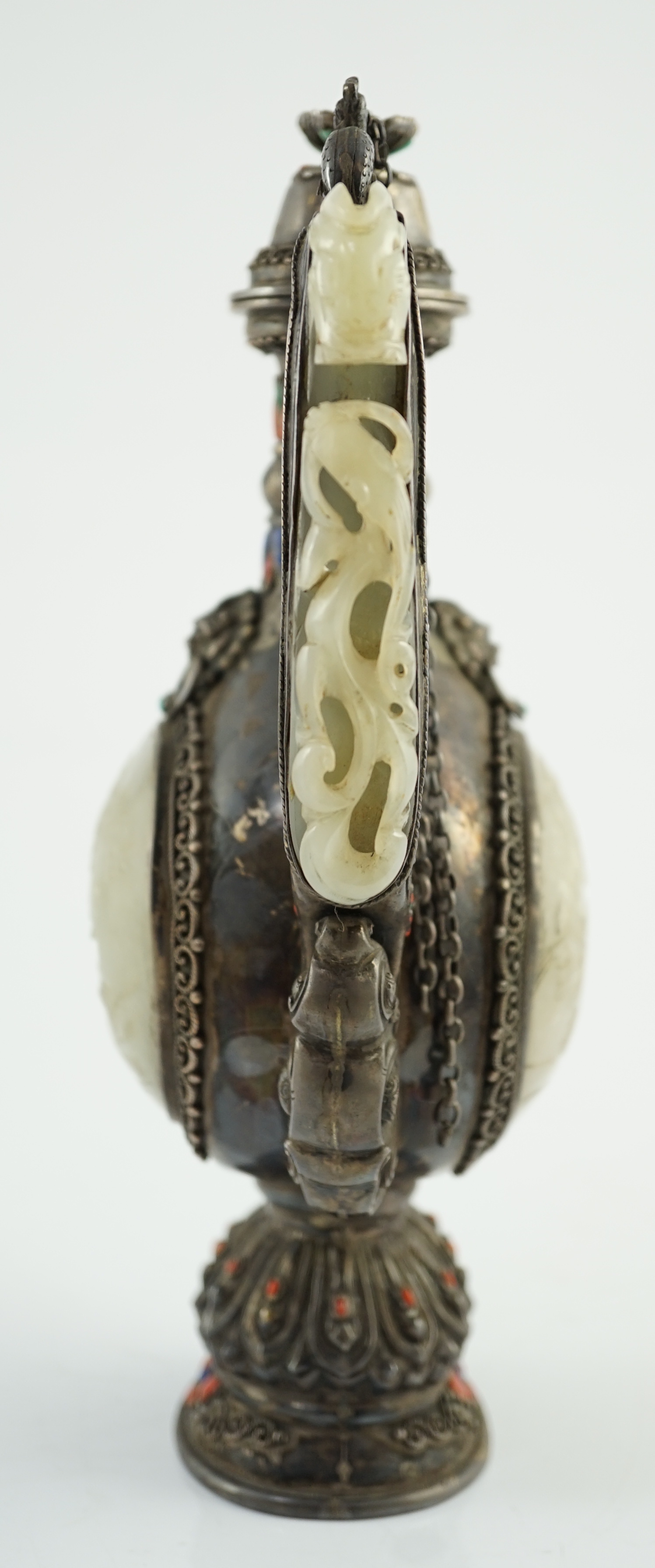 A Tibetan silver, jade, coral and hardstone mounted ewer, late 19th century, the Chinese pale celadon jades, 18th/19th century finial lacking stones